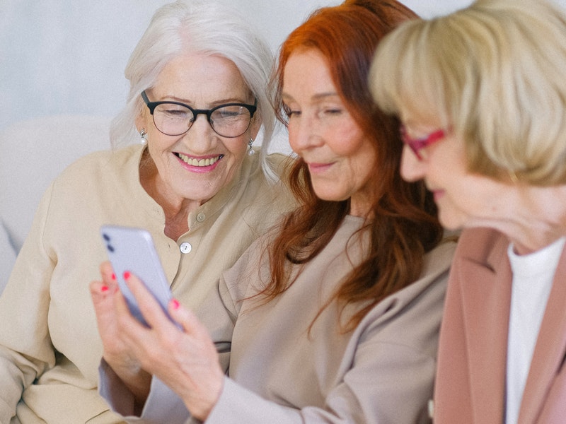 mujeres viendo un dispositivo movil